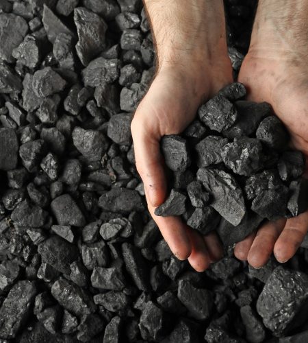 Man,Holding,Coal,In,Hands,Over,Pile,,Top,View.,Space