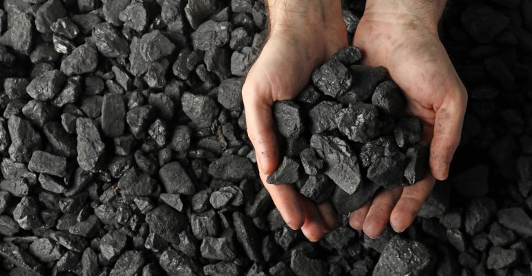 Man,Holding,Coal,In,Hands,Over,Pile,,Top,View.,Space
